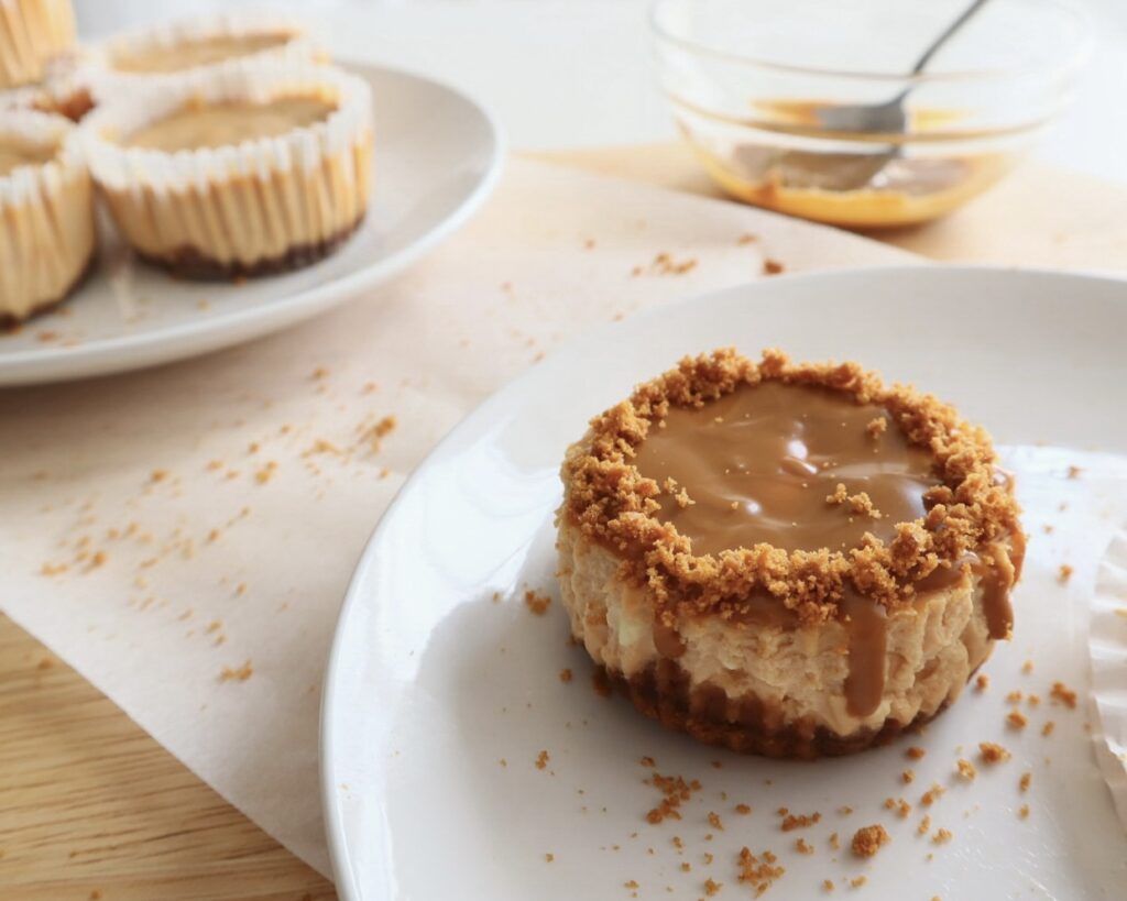 Cheesecake topped with smooth Biscoff spread in the foreground