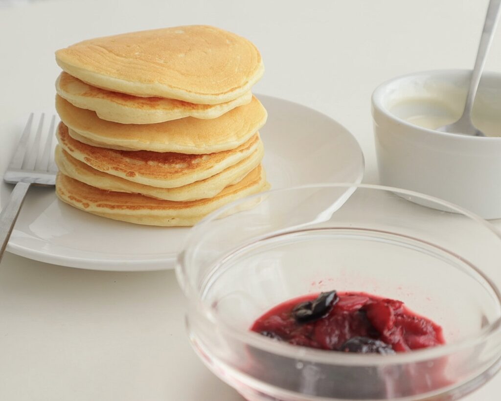 Stack Of Cooked, Plain Protein Pancakes with Yoghurt and Berry Topping in the shot