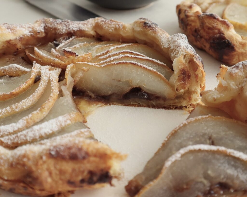 Powdered sugar on top of sliced pear galette