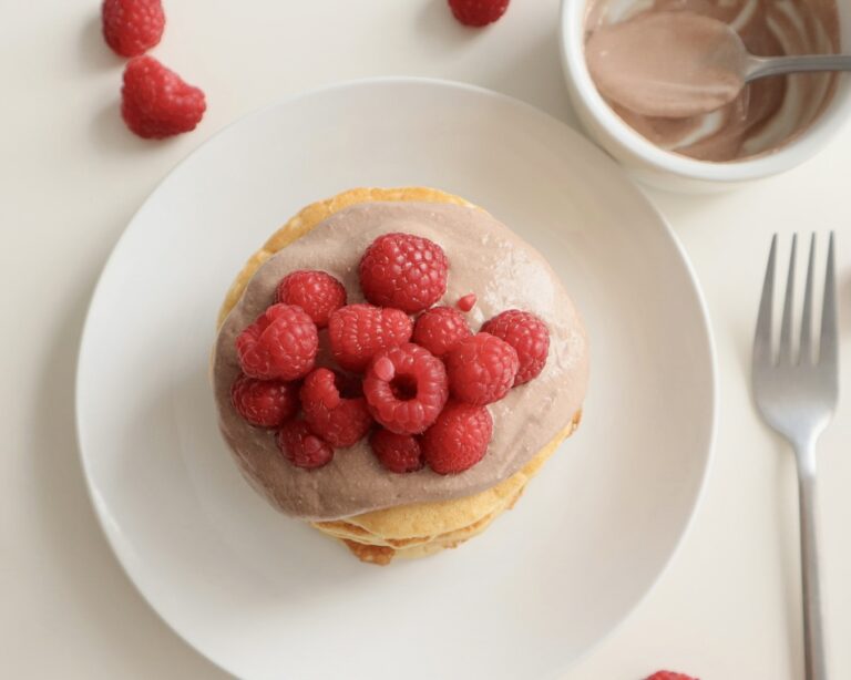 Top view of a stack of cottage cheese pancakes with raspberries