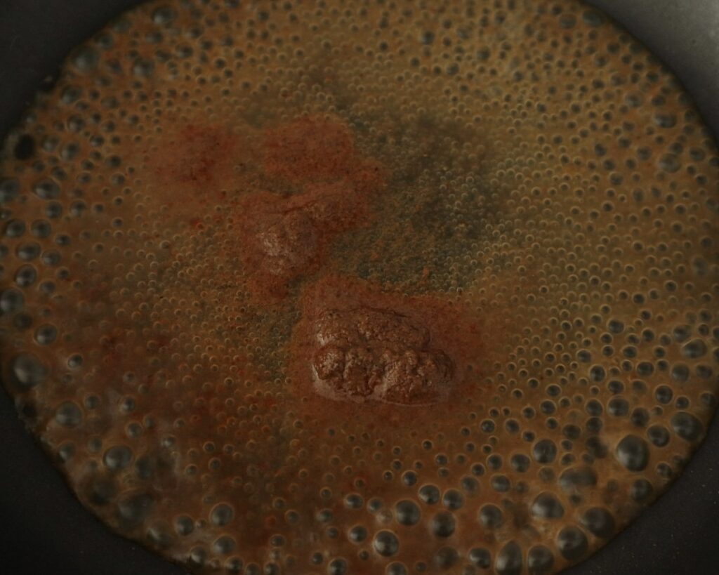 Korma paste simmering in water over low heat