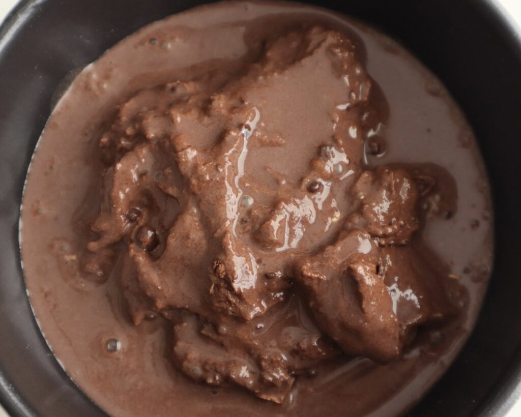 Chocolate protein sauce poured over the chocolate mug cake before placing it into the microwave