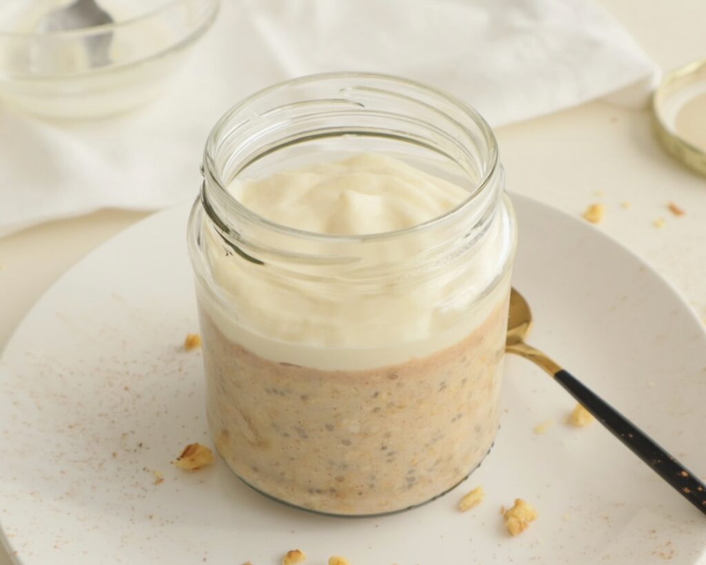 Side view of banana overnight oats with vanilla protein yogurt topping